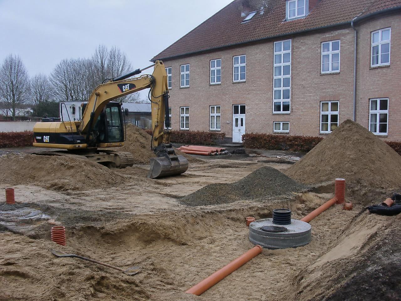 Byggeplads under renovering af en ejendom med stillads og materialer