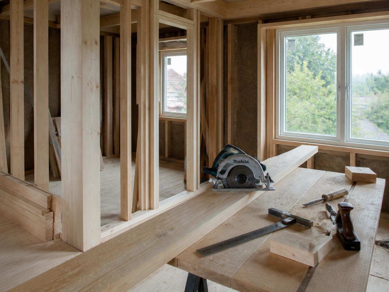 Tømrer der arbejder med trækonstruktion i et rum under renovering
